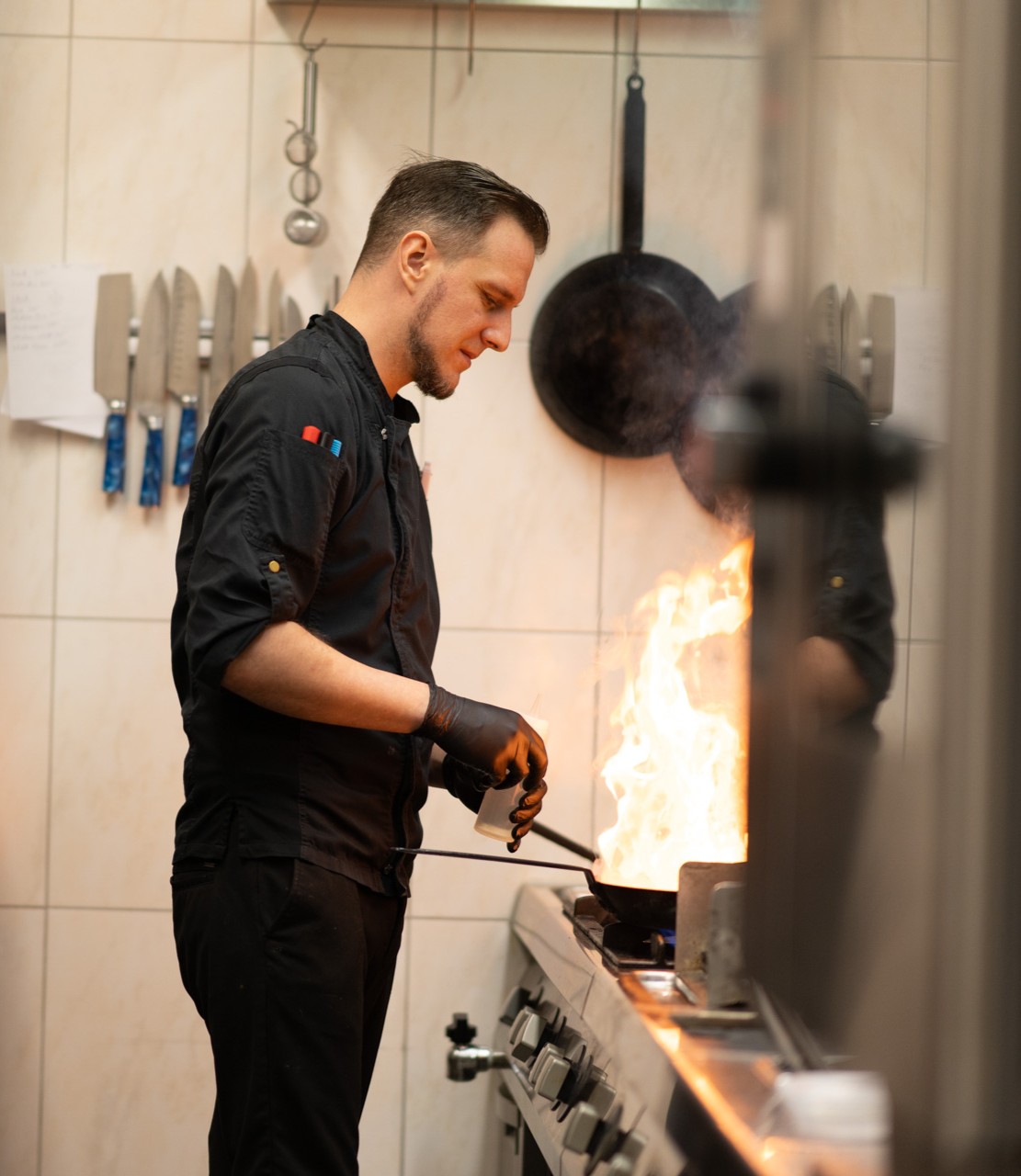 Cook working with burning pan.